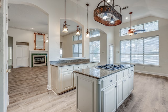 kitchen with white cabinetry, stainless steel gas cooktop, and a healthy amount of sunlight