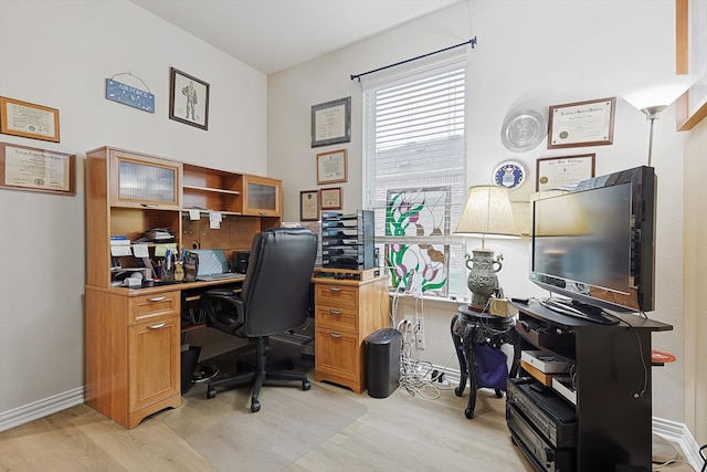 home office with light hardwood / wood-style floors