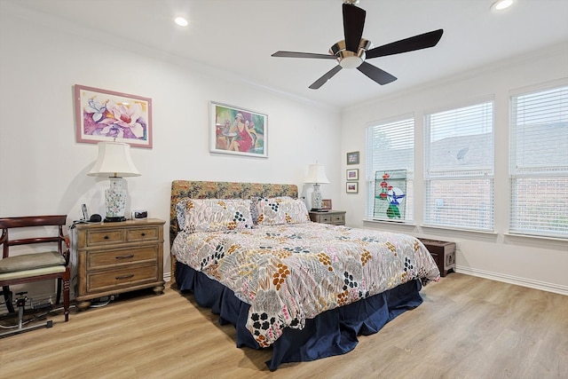 bedroom with ceiling fan, multiple windows, light hardwood / wood-style flooring, and crown molding