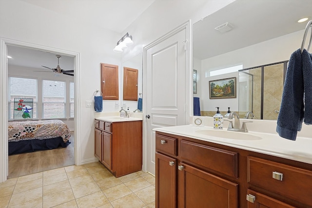 bathroom featuring a shower with door, vanity, tile patterned flooring, and ceiling fan