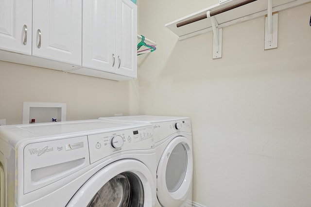 washroom featuring separate washer and dryer and cabinets