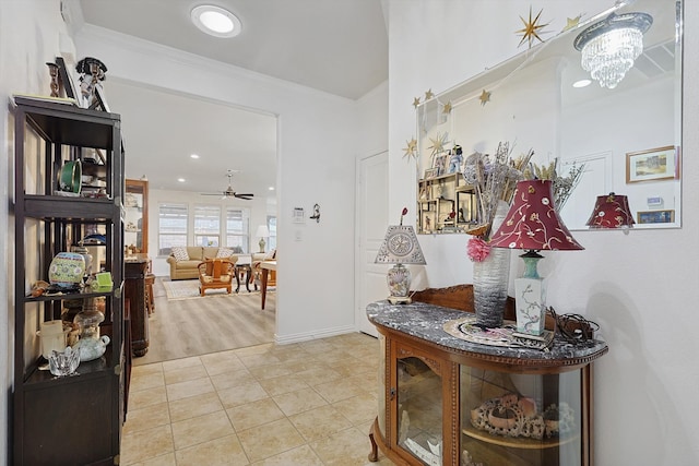 hallway featuring ornamental molding, light tile patterned floors, and an inviting chandelier