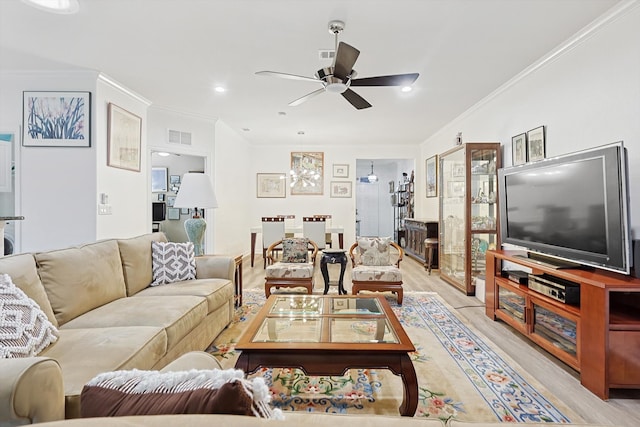 living room with ornamental molding, light hardwood / wood-style flooring, and ceiling fan