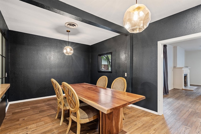 dining area with beamed ceiling and hardwood / wood-style flooring