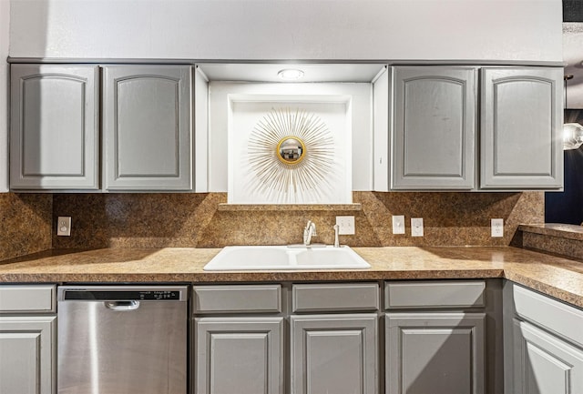 kitchen featuring stainless steel dishwasher, decorative backsplash, gray cabinetry, and sink