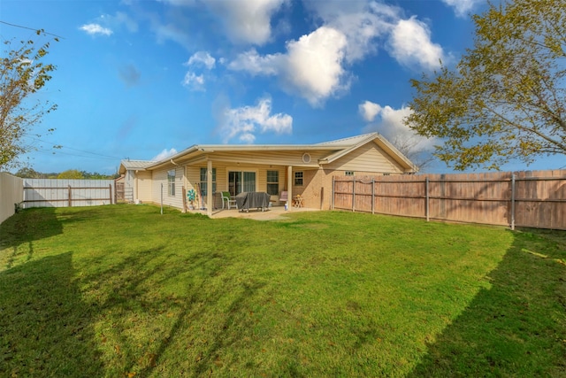 rear view of house featuring a patio area and a yard