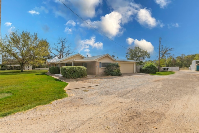 ranch-style home featuring a garage and a front lawn