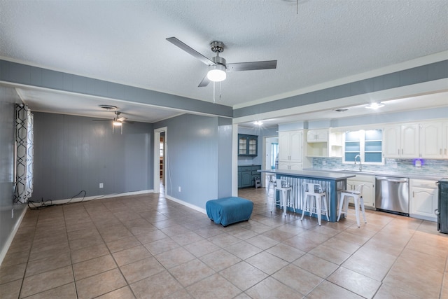 interior space featuring white cabinetry, tasteful backsplash, a breakfast bar area, wooden walls, and dishwasher