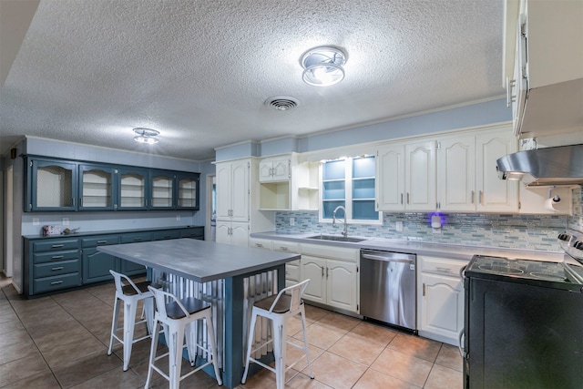 kitchen with stainless steel appliances, white cabinetry, light tile patterned floors, and a breakfast bar