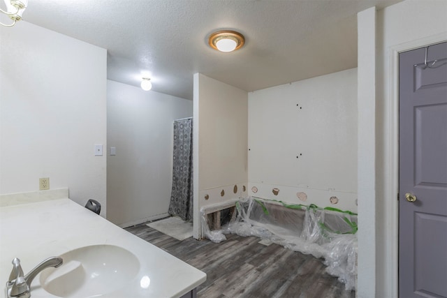 bathroom with vanity, wood-type flooring, and a textured ceiling