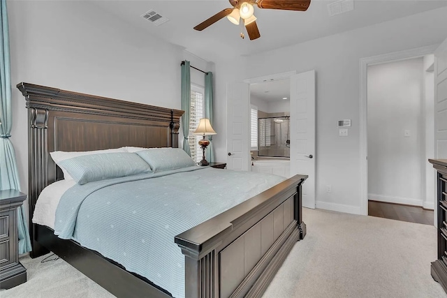 bedroom featuring light colored carpet, ceiling fan, and ensuite bathroom