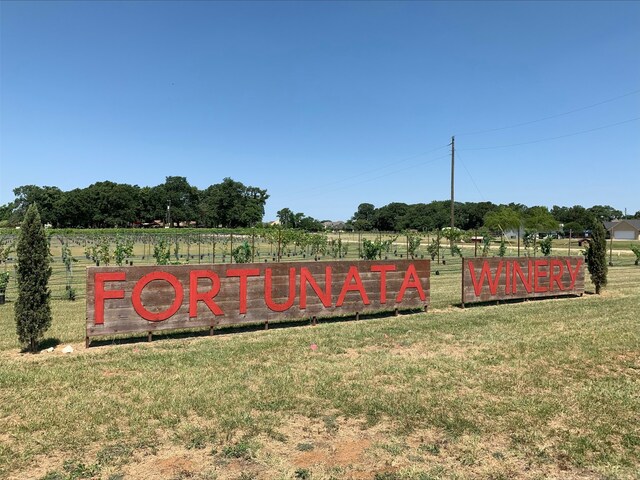 community / neighborhood sign featuring a lawn and a rural view