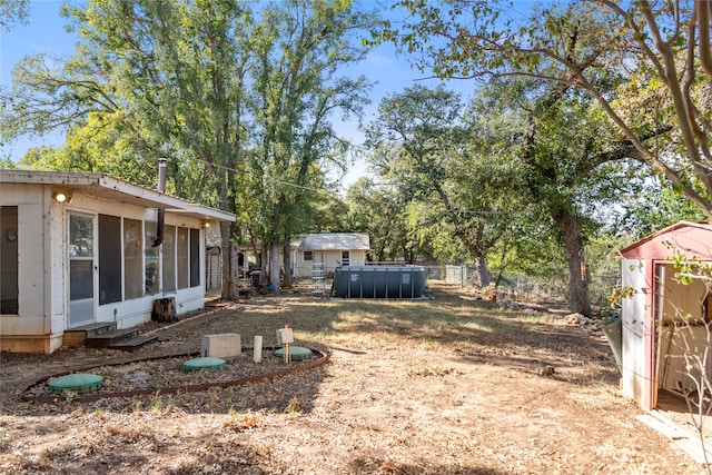 view of yard with a storage unit and a pool