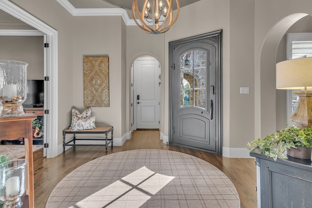 foyer with a chandelier, crown molding, dark hardwood / wood-style floors, and plenty of natural light