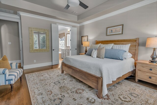 bedroom with hardwood / wood-style flooring, ensuite bath, ornamental molding, and ceiling fan