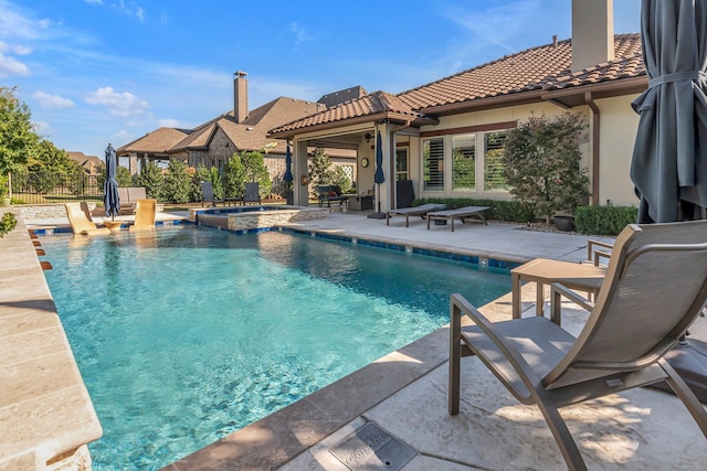 view of swimming pool featuring a patio and an in ground hot tub