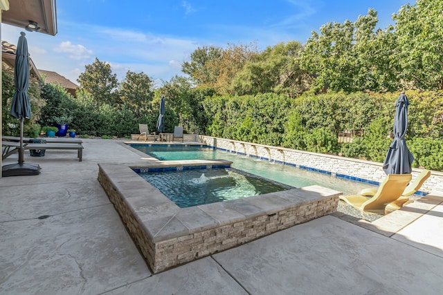 view of pool with a patio area and an in ground hot tub