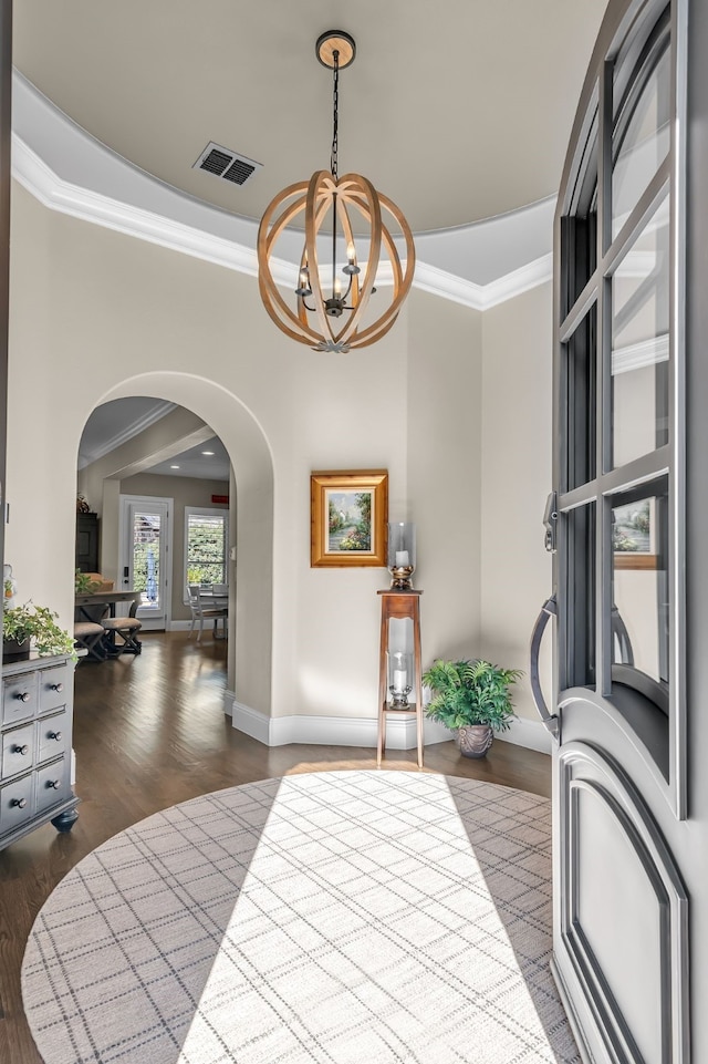 foyer featuring a chandelier, crown molding, and dark hardwood / wood-style flooring