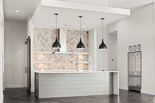 kitchen featuring high quality fridge, dark wood-type flooring, sink, and decorative light fixtures