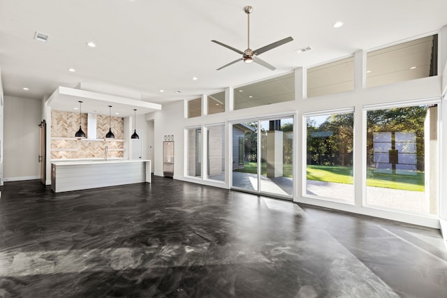 unfurnished living room featuring a high ceiling