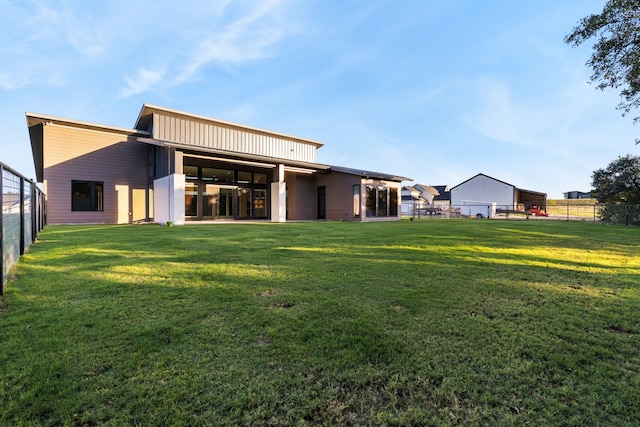 rear view of property featuring a lawn