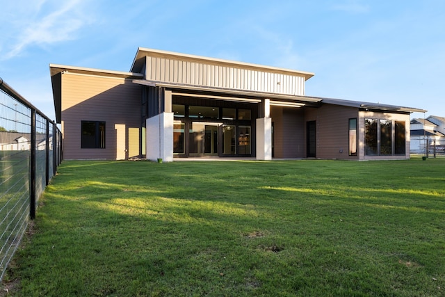 rear view of house featuring a lawn