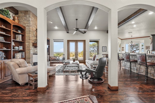 living room featuring dark hardwood / wood-style floors, beam ceiling, a textured ceiling, and ceiling fan with notable chandelier