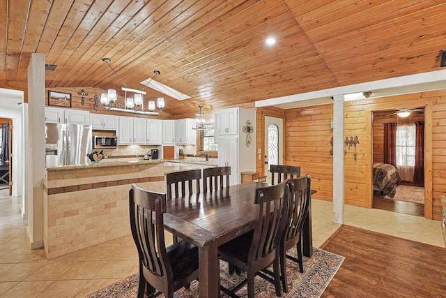 dining space featuring vaulted ceiling, wood walls, and wood ceiling