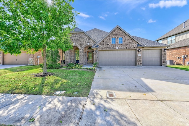 view of front of property featuring central AC unit, a garage, and a front yard