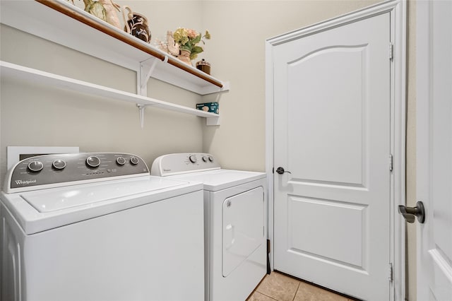 laundry area with washing machine and dryer and light tile patterned floors