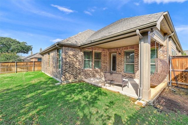 back of house with a lawn and a patio