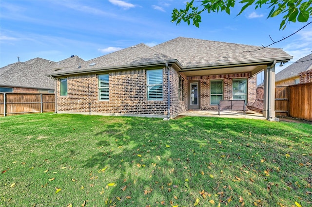 rear view of house with a lawn and a patio