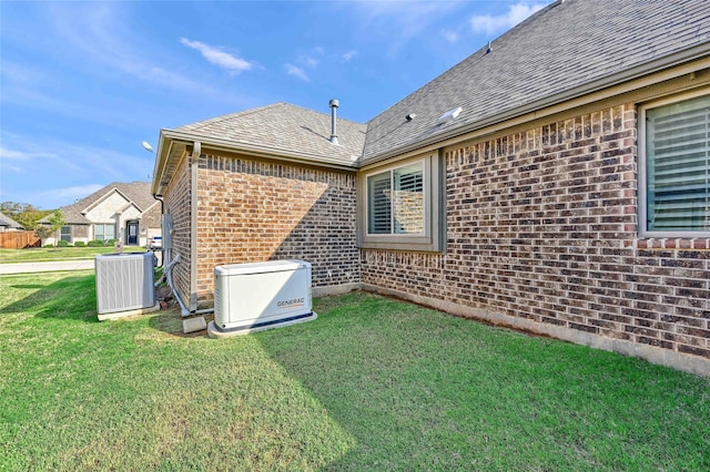 rear view of house featuring a lawn and central air condition unit