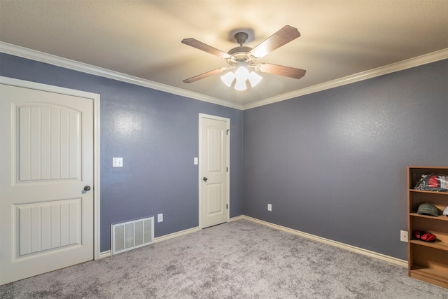 carpeted spare room featuring ceiling fan and crown molding