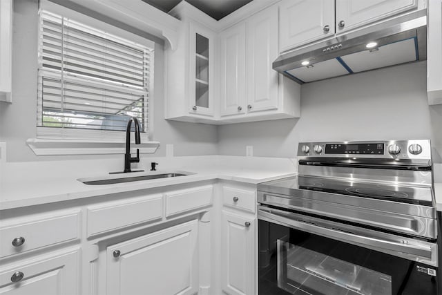 kitchen featuring white cabinetry, stainless steel electric range oven, and sink