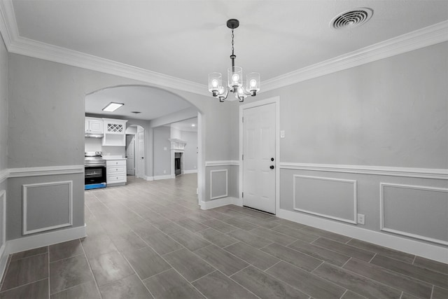 unfurnished dining area with dark hardwood / wood-style floors, crown molding, and an inviting chandelier