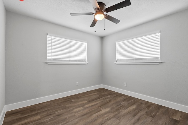 unfurnished room with plenty of natural light, dark wood-type flooring, and ceiling fan