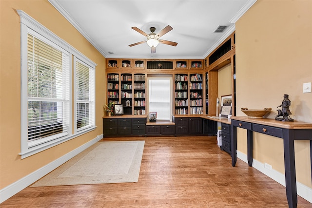 unfurnished office with hardwood / wood-style flooring, ceiling fan, crown molding, and built in desk