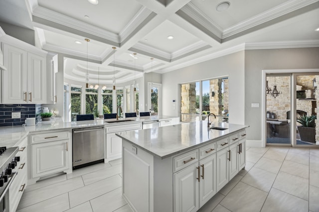 kitchen with stainless steel appliances, backsplash, sink, an island with sink, and white cabinets