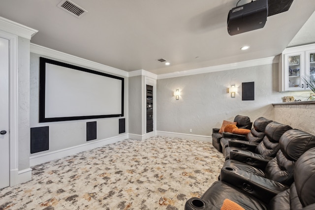 carpeted home theater room featuring ornamental molding