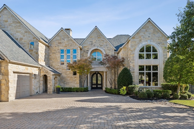 6800 Rainwood Dr, Plano, TX 75024 - french provincial home featuring french doors, stone siding, a chimney, and decorative driveway