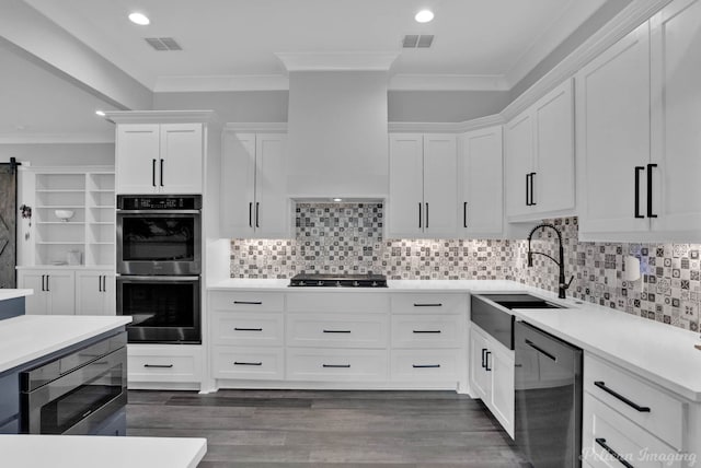 kitchen with white cabinetry, sink, appliances with stainless steel finishes, and ornamental molding