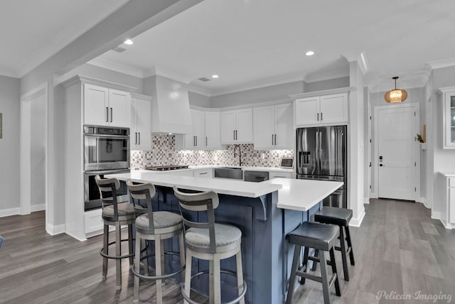 kitchen featuring stainless steel appliances, custom exhaust hood, white cabinets, and decorative backsplash