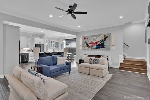 living room featuring hardwood / wood-style flooring, ceiling fan, and crown molding