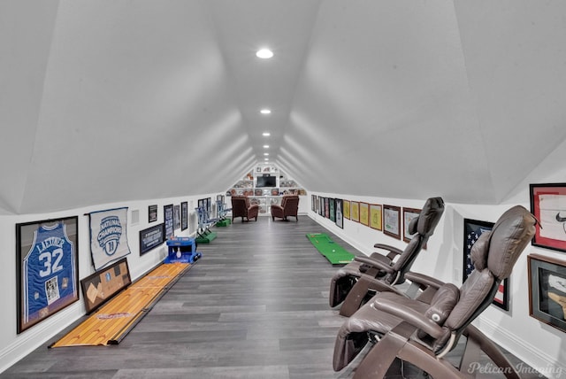 exercise room featuring vaulted ceiling and hardwood / wood-style floors