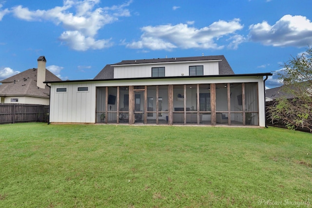 back of house featuring a yard and a sunroom