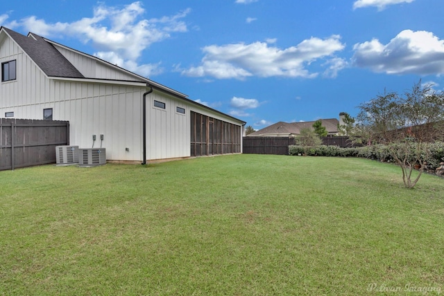 view of yard featuring a sunroom and central air condition unit