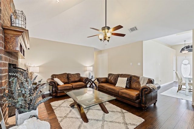 living room with ceiling fan, lofted ceiling, dark hardwood / wood-style floors, and a brick fireplace