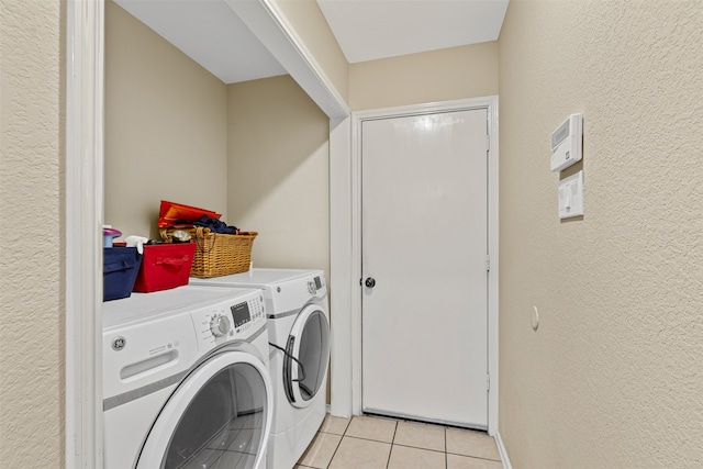 laundry room with washing machine and dryer and light tile patterned floors