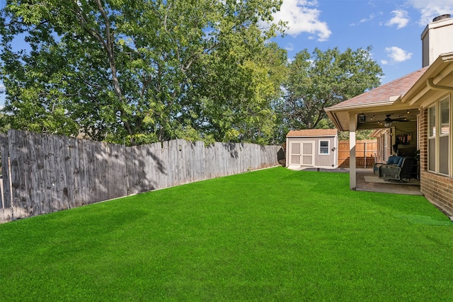 view of yard featuring ceiling fan, a patio, and a shed